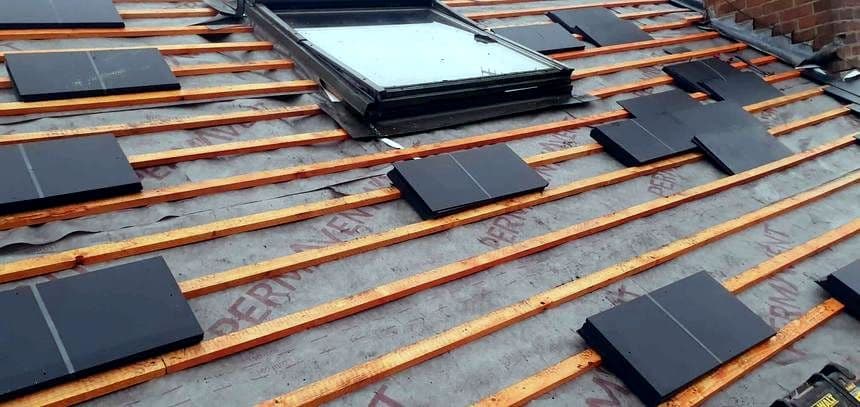 Slates being laid on battens